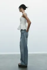 Top palabra de honor blanco con hombros descubiertos, corte ajustado y bajo con peplum.