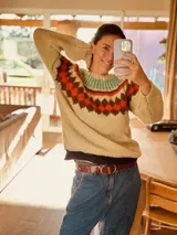 Sweater tejido a mano en mohair color beige con cuello redondo y diseño geométrico en tonos marrón, naranja y verde.