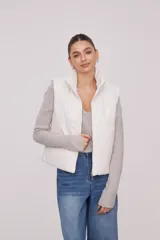 Chaleco blanco con cuello alto y cierre frontal con cremallera.