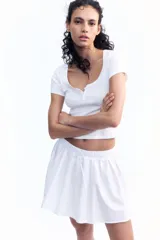 Remera blanca de algodón con escote en U y tapeta de botones.