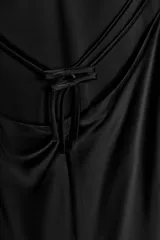 Vestido midi negro de satén con escote en V y tirantes finos. Detalle de tiras cruzadas en la espalda con lazadas. Cierre trasero con cremallera.