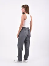 Pantalón de vestir color negro, de corte recto, con bolsillos laterales y traseros. Se ajusta a la cintura con cinturón de cuero marrón.