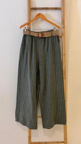 Pantalón verde con rayas verticales blancas, corte ancho, cintura elástica y cinturón de rafia extraíble.