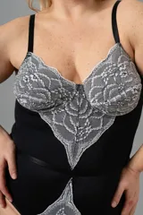 Body negro con puntilla elastizada blanca en busto y cintura. Breteles regulables y broche en entrepierna.