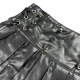 Minifalda negra de cuero sintético con tablas y detalles de remaches metálicos.