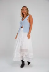 Falda larga blanca de estilo romántico, con volados en el ruedo y detalles de puntilla y encaje bordado.