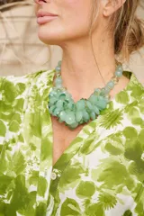 Collar corto de cuentas de vidrio facetado color verde agua, con cuentas pequeñas transparentes y cierre de mosquetón dorado.