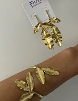 Aros colgantes dorados con forma de hojas texturizadas.