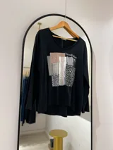 Remera negra de manga larga con escote en pico y estampa sublimada en el frente con la frase "You will shine".