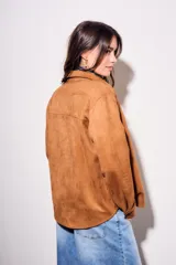 Camisa color marrón de gamuza sintética, de corte recto, con cuello clásico, cierre frontal con botones y mangas largas.