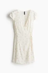 Vestido corto de crepé de viscosa con estampado floral, escote en V y manga japonesa. Tiene frente cruzado con tiras para atar, cuerpo entallado y falda con leve vuelo.