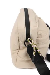 Bandolera color beige con correa negra ajustable, cierre superior y dos bolsillos frontales con cierre.