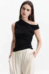 Remera negra asimétrica de un hombro con frunces laterales.