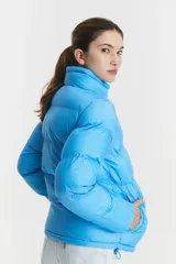 Campera puffer celeste con cuello alto y cierre de botones a presión.