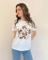 Remera blanca de algodón con estampa de flor color marrón con contorno dorado y centro con strass. Corte clásico y mangas cortas.