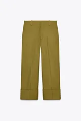 Pantalón chino color verde oliva de tiro medio con cintura con trabillas, raya planchada en delantero y cierre frontal con cremallera, botón y gancho metálico.