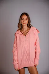 Buzo de punto color rosado, con cuello polo y cierre frontal parcial, de manga larga y diseño holgado.