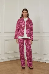 Pantalón jean de corte recto con estampado abstracto en tonos rosa y bordó.