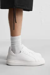 Zapatillas deportivas blancas de cuero sintético, con cordones y suela de goma con plataforma.