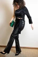 Top negro de un hombro con manga larga acampanada y corte ajustado.