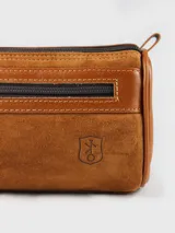 Neceser de cuero color marrón con cierre superior y bolsillo frontal con cierre.