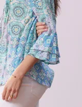 Blusa de gasa estampada con cuello a la base, escote en V, botones y manga ¾ amplia.