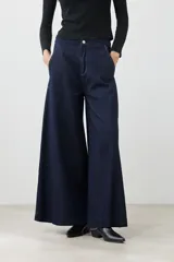 Pantalón de jean wide leg color azul oscuro con cintura alta y cinturón de cadena plateada.