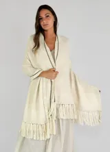 Chaleco tipo pashmina tejido en color blanco con detalles plateados y flecos en el borde inferior.
