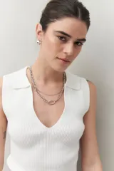 Top negro tejido sin mangas con escote en V y cuello tipo solapa.