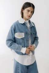 Campera de jean celeste con cuello y bolsillo con detalles de crochet blanco.