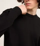 Remera de manga larga color blanco, confeccionada en algodón, con cuello redondo y puños ajustados.