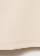 Camiseta color crema de corte recto, cuello redondo y manga corta. Confeccionada en tejido mezcla de poliéster, algodón y elastano.