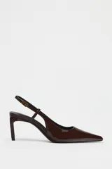 Zapato de tacón destalonado color marrón charol, con punta fina y tira trasera con hebilla.