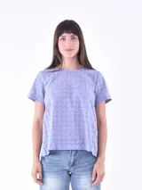 Blusa azul claro con pequeños calados en forma de flor.