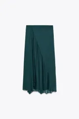 Falda midi verde esmeralda de satén, de tiro alto y corte evasé, con bajo asimétrico y forro interior.