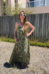 Vestido largo verde con estampado abstracto en blanco y negro, de fibrana, con breteles finos y volado en el ruedo.