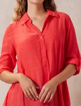 Camisa color beige claro, de corte recto y mangas 3/4 con botón para sujetar.