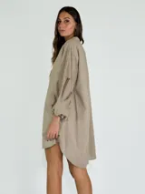 Vestido corto color ocre, con cuello mao, mangas largas abullonadas con detalle de encaje y corte evasé.