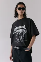 Remera negra de algodón con estampado del logo de Metallica y la imagen de la banda Damage Inc. 1986. Corte oversized con cuello redondo ribeteado, hombros caídos y bajo recto.