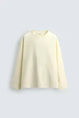 Camisa color crema de corte amplio, confeccionada en popelín de algodón. Tiene cuello redondo y mangas largas.