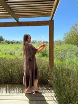 Vestido marrón de lino, largo, con mangas abullonadas y volado inferior más largo en la parte trasera.