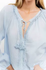 Blusa rosa de algodón con escote en V con cordones y detalle de volados.