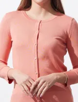 Cardigan tejido en hilado fino, color rosado, con escote redondo y cierre frontal con botones.