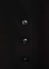 Chaleco negro con cuello en V y cierre frontal con botones.