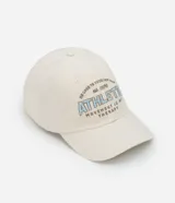 Gorra de sarga color crema con visera curva y bordado frontal con la palabra "ATHLETIC" en celeste y gris.