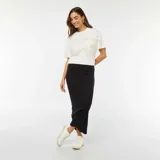 Camiseta blanca de algodón con cuello redondo y mangas cortas. Presenta un bolsillo en el pecho con dos lazos decorativos.