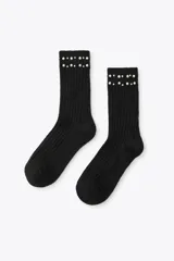 Calcetines negros de punto canalé con detalle de perlas sintéticas en el borde superior.