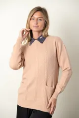 Sweater rojo de punto con cuello redondo y mangas largas. Presenta detalle de trenzado y distintos puntos en el frente, y dos bolsillos delanteros.