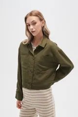 Chaqueta verde militar de lino, corte holgado, con cuello camisero, cierre frontal con botones, mangas largas y bolsillos de parche en el pecho.