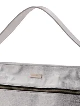 Cartera plateada de cuero graneado, con doble correa, cierre metálico con tirador de cuero, chapita de marca metálica, detalles interiores con logo de marca e inscripción "HECHO EN URUGUAY" y forro textil.